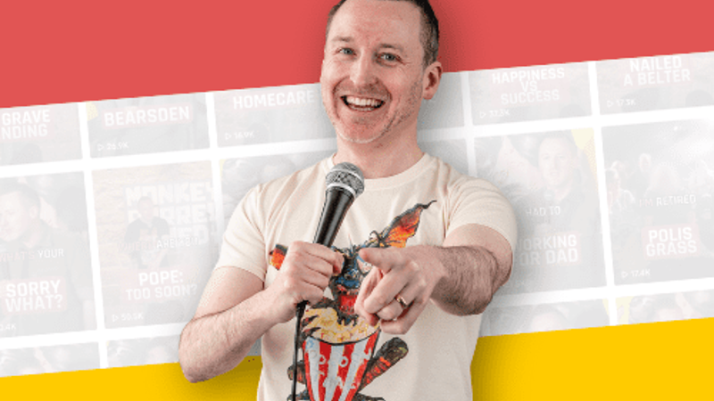 Stuart Mitchell with microphone and pointing