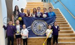 Education Convener Councillor Clare Steel with Aitkenbar Primary School pupils and staff holding the Gold School Sport Award banner.