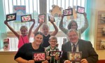 Cllr McGinty and Cllr Lennie with children, holding the stained glass window art they created.