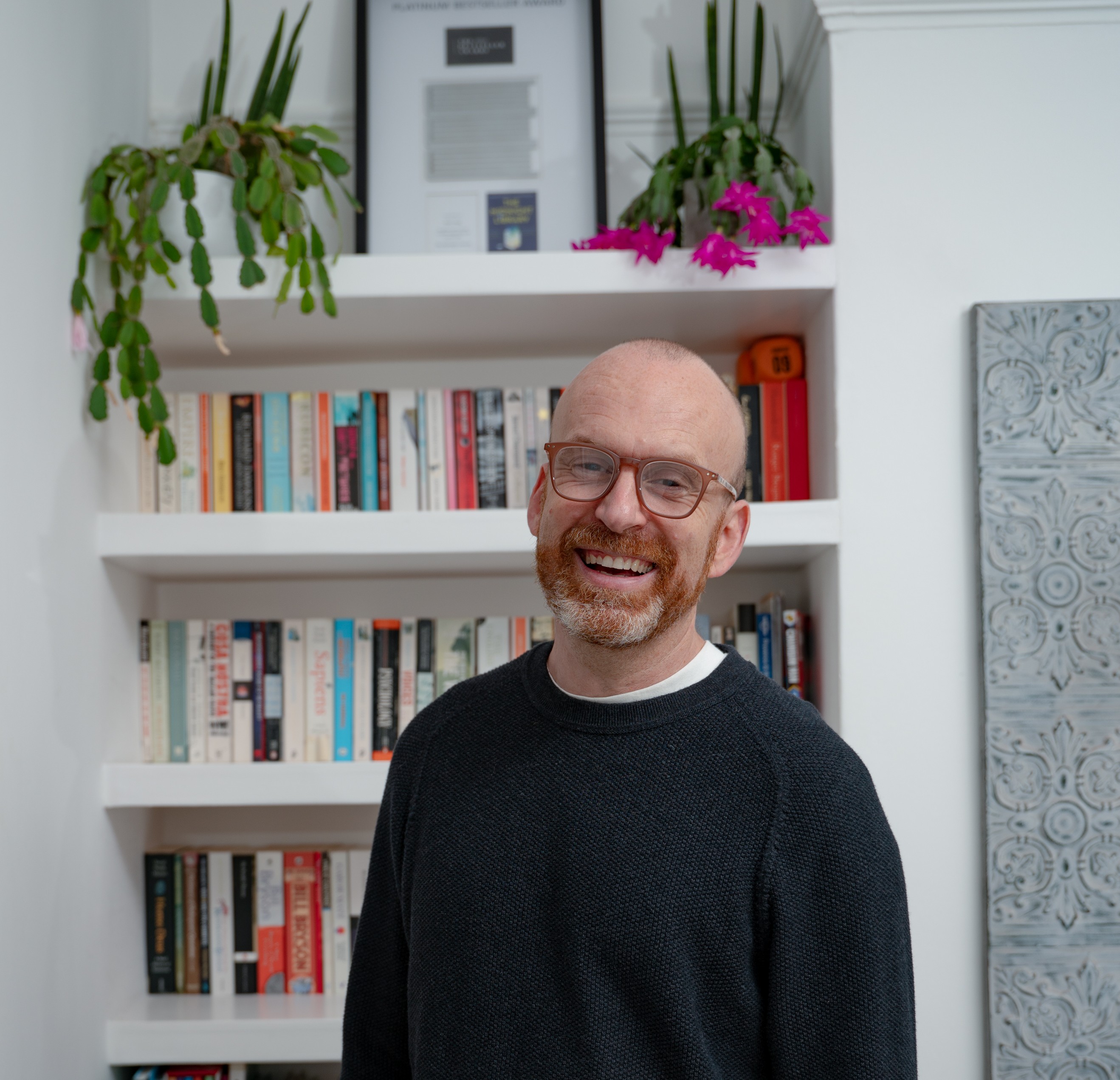 Photo of Matt Haig standing in front of a bookcase 
