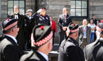 Salute during armed forces day parade with armed forces personnel marching past Clydebank Town Hall