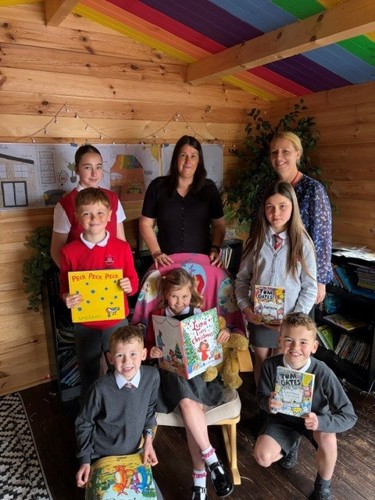 Primary school pupils holding books alongside councillors to celebrate the launch of the new Reading Pledge.